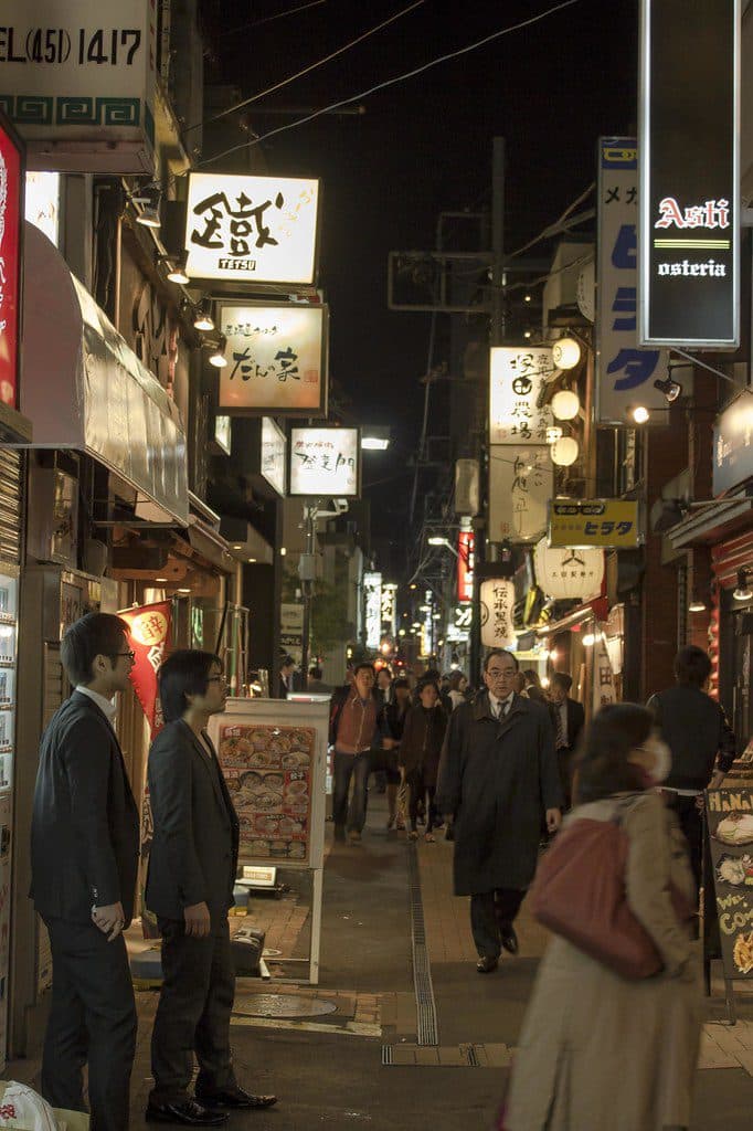 Narrow alley of glowing izakaya signs and late diners